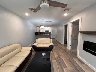1727 NW 31st St, Oklahoma City, OK 73118 - living room with dark wood finished floors, a ceiling fan, and a fireplace