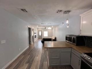 1727 NW 31st St, Oklahoma City, OK 73118 - kitchen with stainless steel appliances, dark wood-style flooring, a peninsula, open floor plan, and hanging light fixtures
