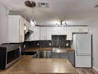 1727 NW 31st St, Oklahoma City, OK 73118 - kitchen with appliances with stainless steel finishes, exhaust hood, and white cabinetry