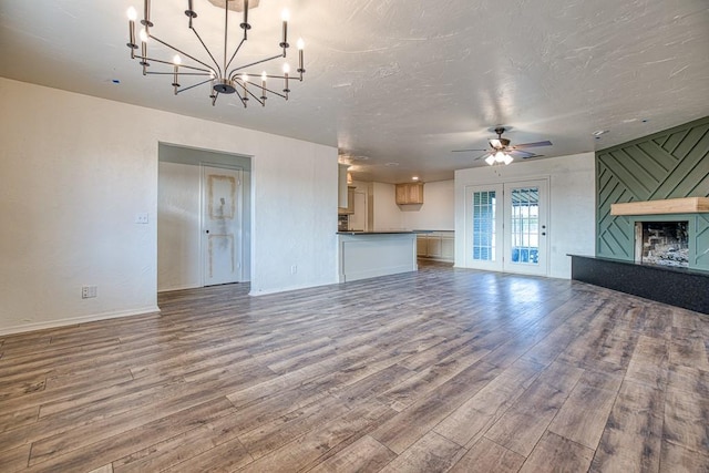 1212 S Main St, Kingfisher, OK 73750 - unfurnished living room featuring wood finished floors, a chandelier, and a ceiling fan