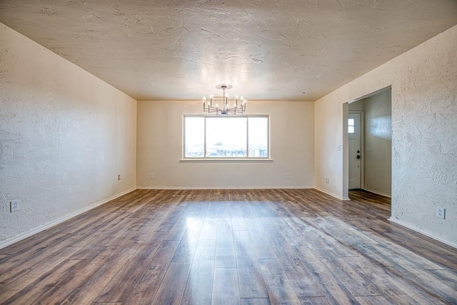 1212 S Main St, Kingfisher, OK 73750 - unfurnished room featuring plenty of natural light, a textured wall, a chandelier, wood finished floors, and a textured ceiling