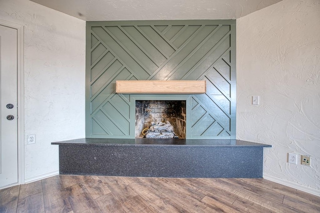 1212 S Main St, Kingfisher, OK 73750 - detailed view of wood finished floors, a textured wall, and a fireplace with raised hearth
