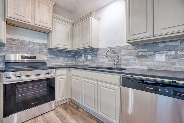 1212 S Main St, Kingfisher, OK 73750 - kitchen with appliances with stainless steel finishes, dark countertops, light wood finished floors, and backsplash