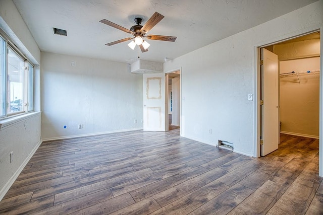 1212 S Main St, Kingfisher, OK 73750 - unfurnished bedroom featuring wood finished floors, a spacious closet, and a ceiling fan