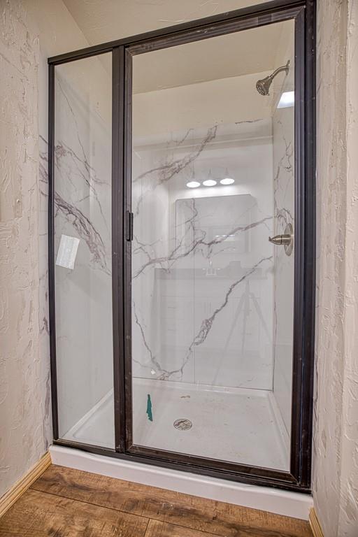 1212 S Main St, Kingfisher, OK 73750 - bathroom featuring a marble finish shower and wood finished floors