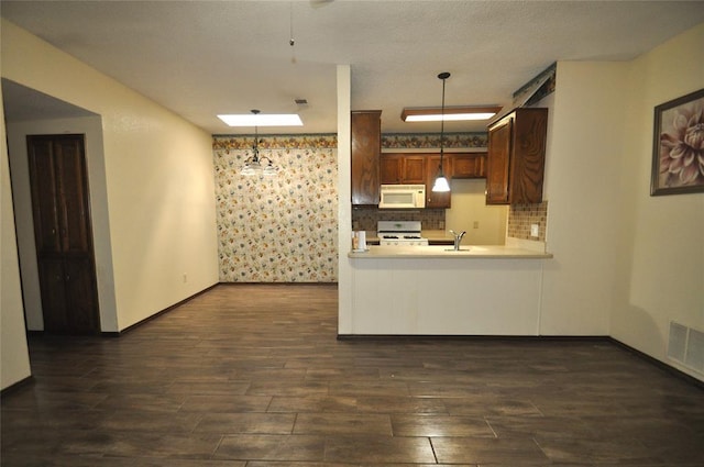 1333 SW 95th St, Oklahoma City, OK 73159 - kitchen with white appliances, dark wood-type flooring, light countertops, tasteful backsplash, and decorative light fixtures