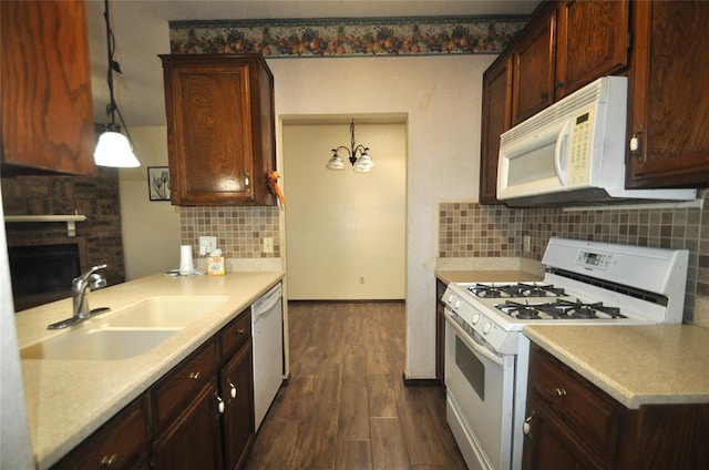 1333 SW 95th St, Oklahoma City, OK 73159 - kitchen featuring white appliances, dark wood-type flooring, decorative backsplash, light countertops, and a fireplace