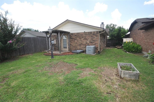 1333 SW 95th St, Oklahoma City, OK 73159 - rear view of house with brick siding, a fenced backyard, a chimney, and a garden