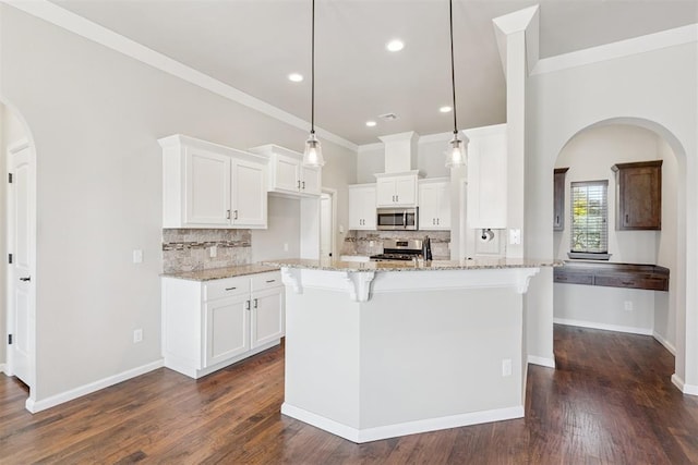 28 143rd St, Oklahoma City, OK 73170 - kitchen featuring stainless steel appliances, arched walkways, light stone countertops, backsplash, and ornamental molding