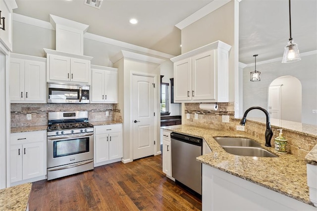 28 143rd St, Oklahoma City, OK 73170 - kitchen featuring stainless steel appliances, ornamental molding, arched walkways, white cabinets, and decorative backsplash