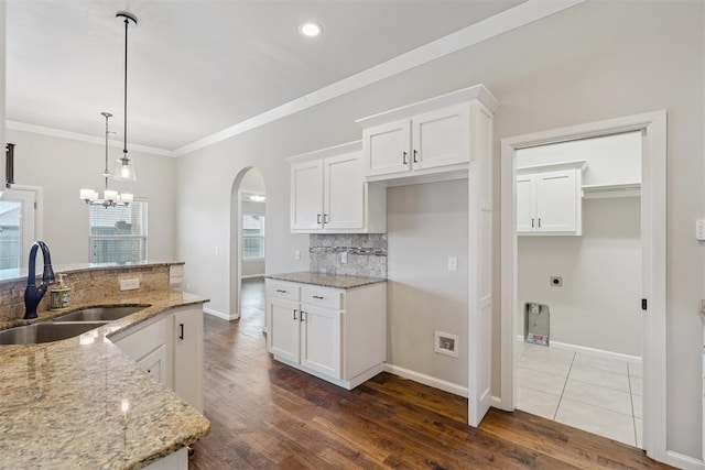 28 143rd St, Oklahoma City, OK 73170 - kitchen with arched walkways, tasteful backsplash, light stone countertops, crown molding, and recessed lighting