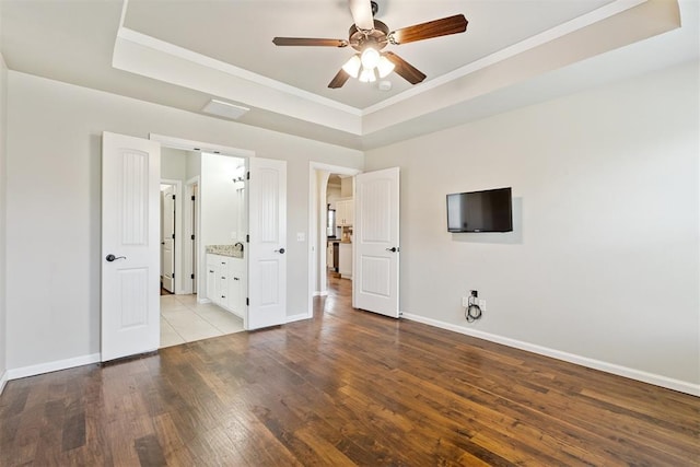 28 143rd St, Oklahoma City, OK 73170 - unfurnished bedroom featuring a raised ceiling, wood finished floors, ornamental molding, ensuite bathroom, and a ceiling fan