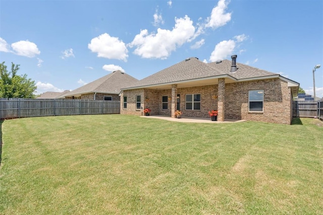 28 143rd St, Oklahoma City, OK 73170 - rear view of house with a fenced backyard, brick siding, a shingled roof, and a patio
