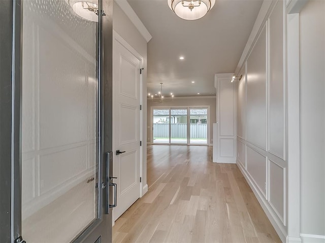 6104 NW 147th Ter, Oklahoma City, OK 73142 - hall featuring a chandelier, recessed lighting, light wood-style floors, crown molding, and a decorative wall