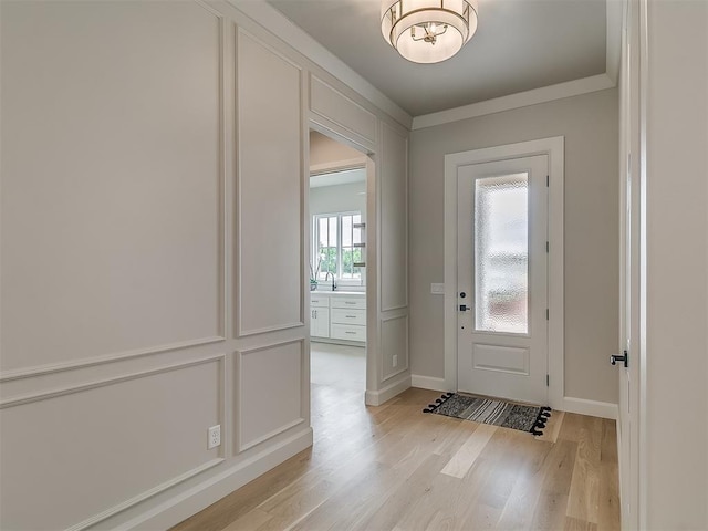 6104 NW 147th Ter, Oklahoma City, OK 73142 - foyer entrance with light wood-style floors, ornamental molding, and a chandelier