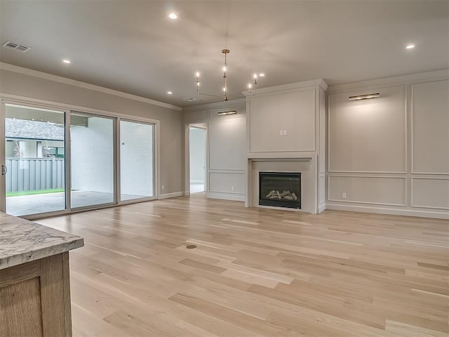 6104 NW 147th Ter, Oklahoma City, OK 73142 - unfurnished living room with ornamental molding, a decorative wall, light wood finished floors, a glass covered fireplace, and recessed lighting