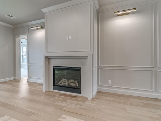 6104 NW 147th Ter, Oklahoma City, OK 73142 - detailed view of wood finished floors, a glass covered fireplace, and crown molding