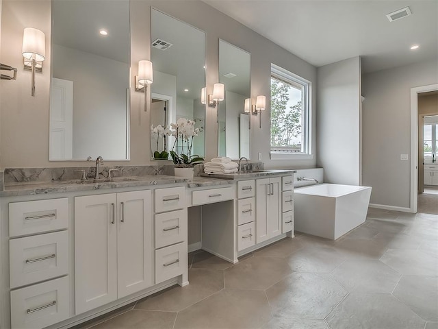 6104 NW 147th Ter, Oklahoma City, OK 73142 - full bath featuring a soaking tub, double vanity, healthy amount of natural light, recessed lighting, and tile patterned floors