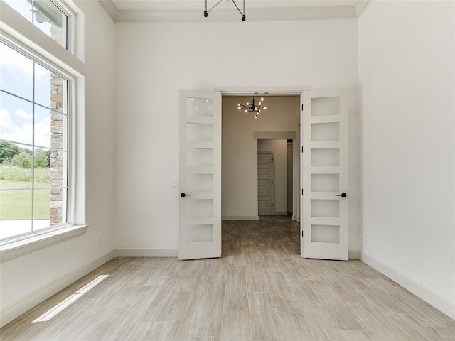 2261 Winter Creek Blvd, Blanchard, OK 73010 - spare room featuring light wood-type flooring, a chandelier, and crown molding