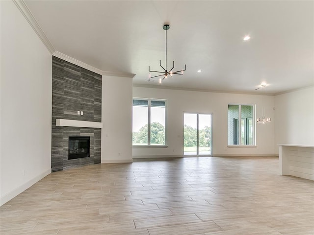2261 Winter Creek Blvd, Blanchard, OK 73010 - unfurnished living room with a chandelier, ornamental molding, plenty of natural light, light wood-type flooring, and a tile fireplace