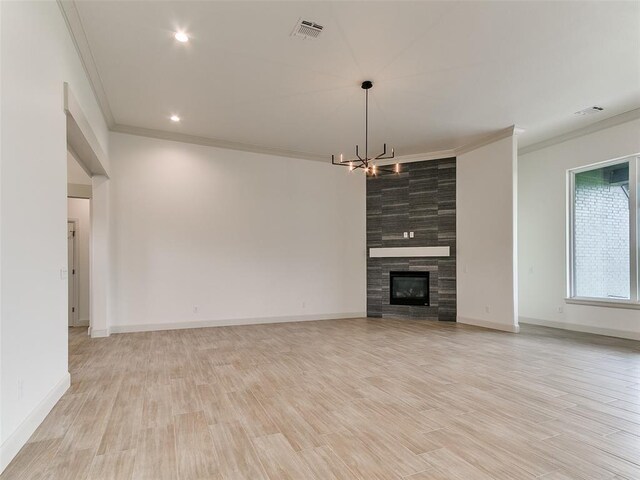 2261 Winter Creek Blvd, Blanchard, OK 73010 - unfurnished living room featuring crown molding, a chandelier, light wood-style floors, a fireplace, and recessed lighting