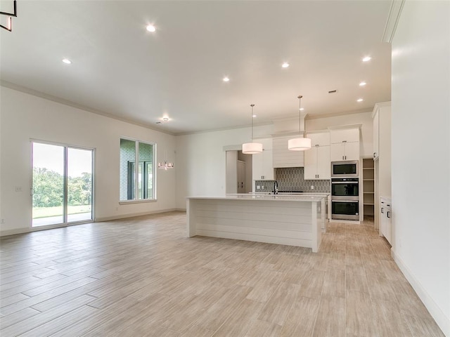 2261 Winter Creek Blvd, Blanchard, OK 73010 - kitchen with appliances with stainless steel finishes, light countertops, decorative backsplash, white cabinets, and ornamental molding
