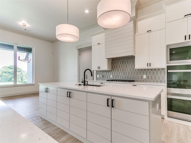 2261 Winter Creek Blvd, Blanchard, OK 73010 - kitchen with stainless steel appliances, decorative backsplash, ornamental molding, light wood finished floors, and white cabinetry
