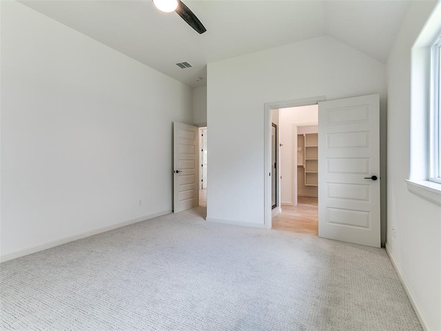 2261 Winter Creek Blvd, Blanchard, OK 73010 - unfurnished bedroom featuring light colored carpet, vaulted ceiling, ceiling fan, and a walk in closet