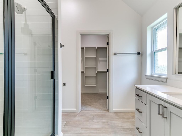 2261 Winter Creek Blvd, Blanchard, OK 73010 - full bath featuring a walk in closet, a shower stall, vanity, wood finished floors, and lofted ceiling