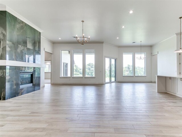 2263 Winter Creek Blvd, Blanchard, OK 73010 - unfurnished living room featuring a chandelier, ornamental molding, light wood-style flooring, recessed lighting, and a fireplace