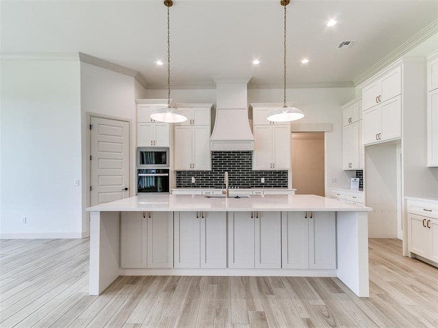 2263 Winter Creek Blvd, Blanchard, OK 73010 - kitchen with black oven, stainless steel microwave, a spacious island, light countertops, and tasteful backsplash