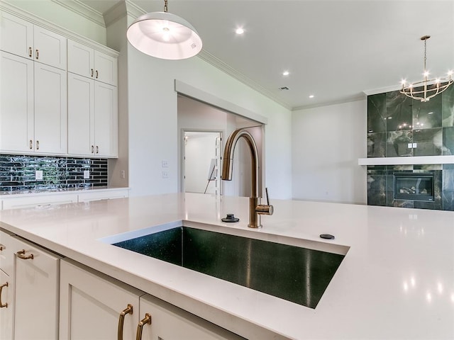 2263 Winter Creek Blvd, Blanchard, OK 73010 - kitchen with light countertops, pendant lighting, crown molding, decorative backsplash, and white cabinets
