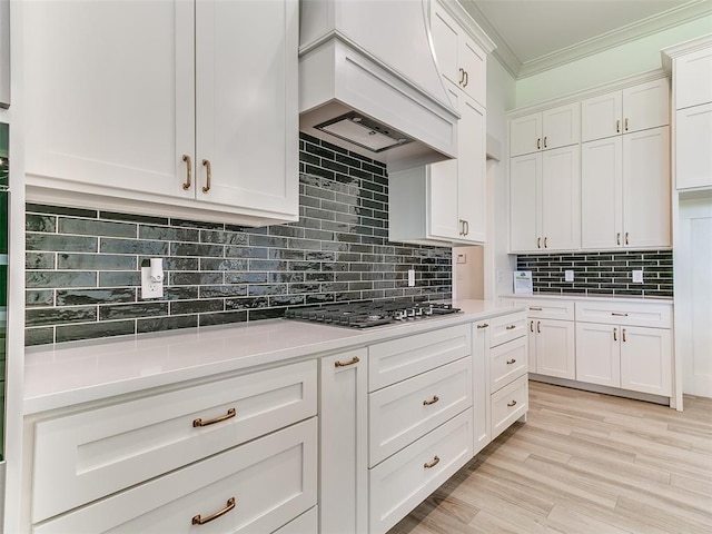 2263 Winter Creek Blvd, Blanchard, OK 73010 - kitchen featuring custom range hood, ornamental molding, light countertops, white cabinets, and decorative backsplash