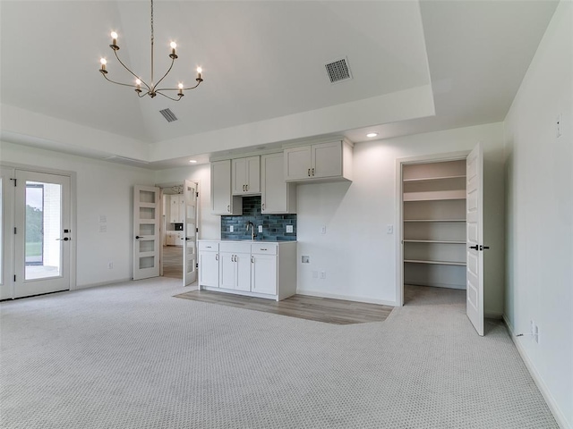 2263 Winter Creek Blvd, Blanchard, OK 73010 - kitchen with light colored carpet, a chandelier, decorative backsplash, recessed lighting, and open floor plan