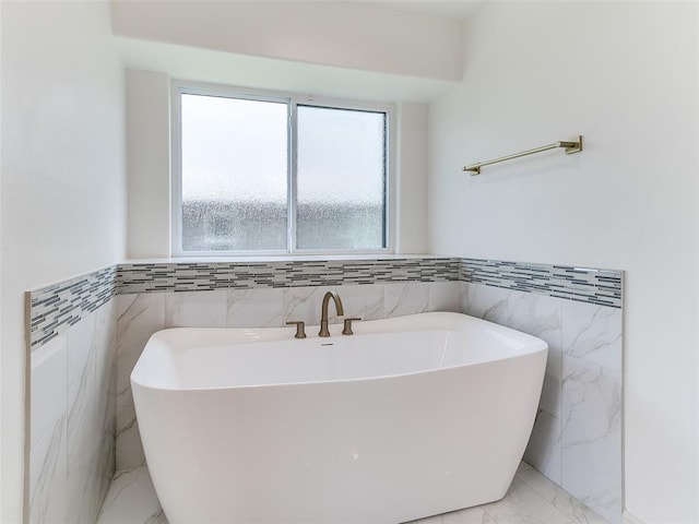 2263 Winter Creek Blvd, Blanchard, OK 73010 - full bathroom with tile walls, marble finish floors, a soaking tub, and a wainscoted wall