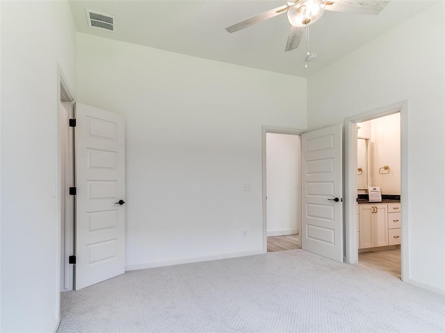 2263 Winter Creek Blvd, Blanchard, OK 73010 - unfurnished bedroom featuring light colored carpet, connected bathroom, and ceiling fan