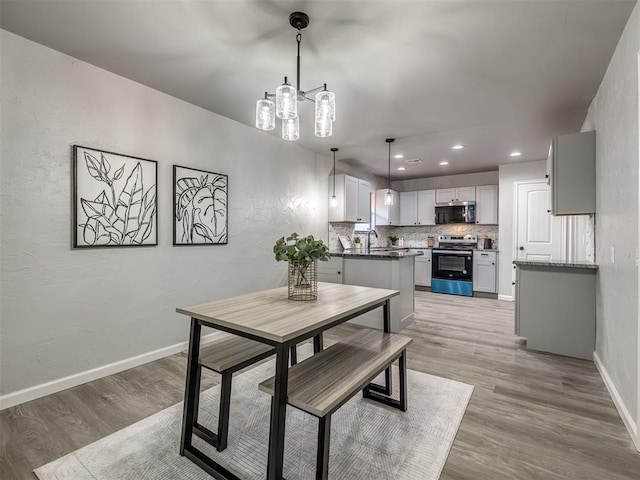313 Ember Glow Dr, Moore, OK 73160 - dining room featuring light wood-type flooring, recessed lighting, a chandelier, and a textured wall