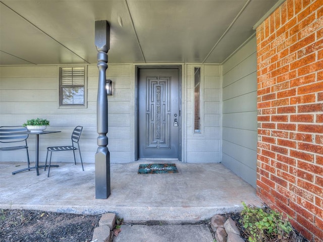 313 Ember Glow Dr, Moore, OK 73160 - view of exterior entry with a porch and brick siding