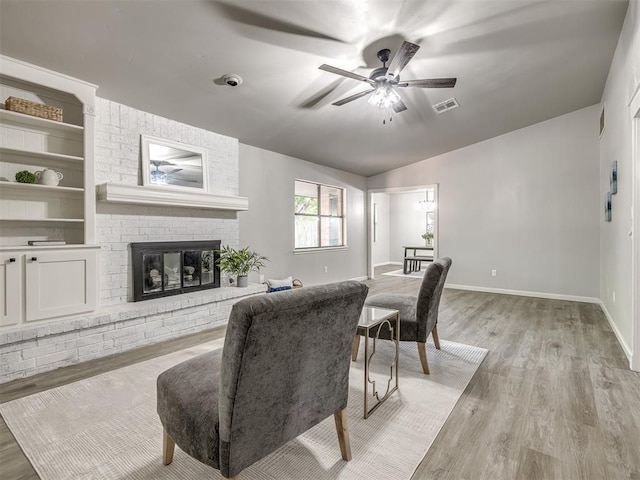 313 Ember Glow Dr, Moore, OK 73160 - living area featuring ceiling fan, lofted ceiling, light wood finished floors, and a brick fireplace