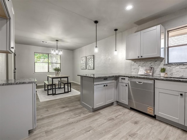 313 Ember Glow Dr, Moore, OK 73160 - kitchen with stainless steel dishwasher, a peninsula, backsplash, light wood finished floors, and recessed lighting