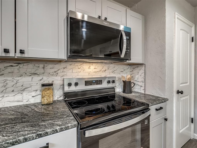 313 Ember Glow Dr, Moore, OK 73160 - kitchen featuring appliances with stainless steel finishes, a textured wall, tasteful backsplash, dark stone countertops, and white cabinets
