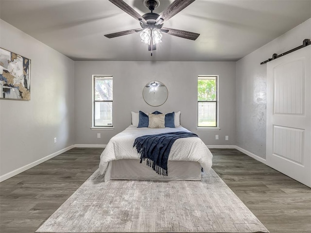313 Ember Glow Dr, Moore, OK 73160 - bedroom with a barn door, dark wood-style floors, and ceiling fan