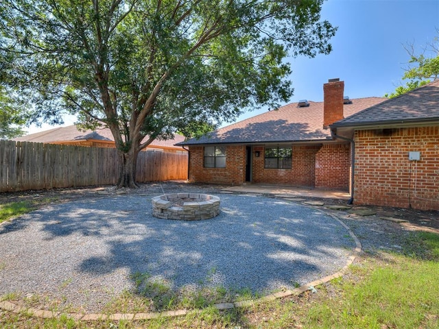 313 Ember Glow Dr, Moore, OK 73160 - rear view of property with an outdoor fire pit, a chimney, brick siding, and a shingled roof