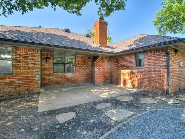 313 Ember Glow Dr, Moore, OK 73160 - rear view of property with brick siding, a shingled roof, a chimney, and a patio area