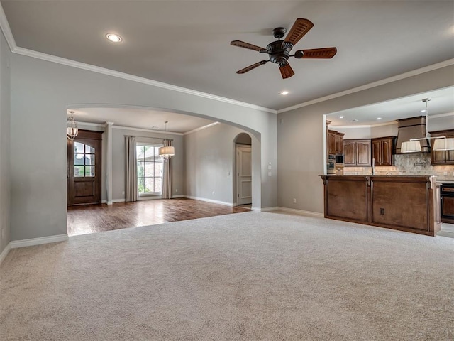 1233 Autumn Creek Dr, Edmond, OK 73003 - unfurnished living room featuring carpet flooring, arched walkways, recessed lighting, a ceiling fan, and crown molding