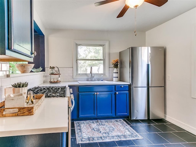 1710 Carlisle Rd, Oklahoma City, OK 73120 - kitchen with appliances with stainless steel finishes, blue cabinetry, light countertops, a ceiling fan, and decorative backsplash