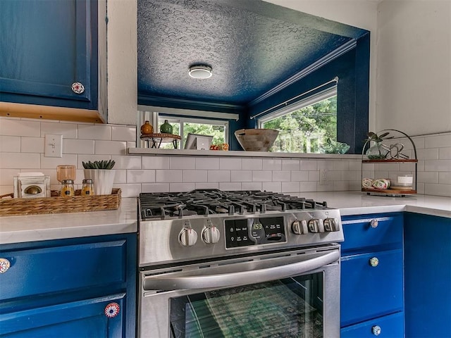 1710 Carlisle Rd, Oklahoma City, OK 73120 - kitchen with stainless steel gas stove, blue cabinetry, a textured ceiling, tasteful backsplash, and healthy amount of natural light