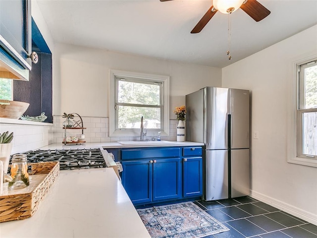 1710 Carlisle Rd, Oklahoma City, OK 73120 - kitchen with freestanding refrigerator, blue cabinetry, light countertops, backsplash, and a ceiling fan