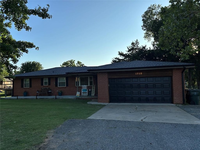 1717 S Webster Dr, Midwest City, OK 73130 - ranch-style home featuring a front yard, asphalt driveway, a garage, brick siding, and covered porch