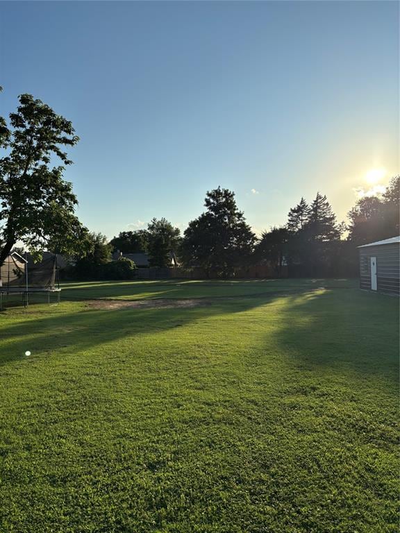 1717 S Webster Dr, Midwest City, OK 73130 - view of grassy yard with a trampoline